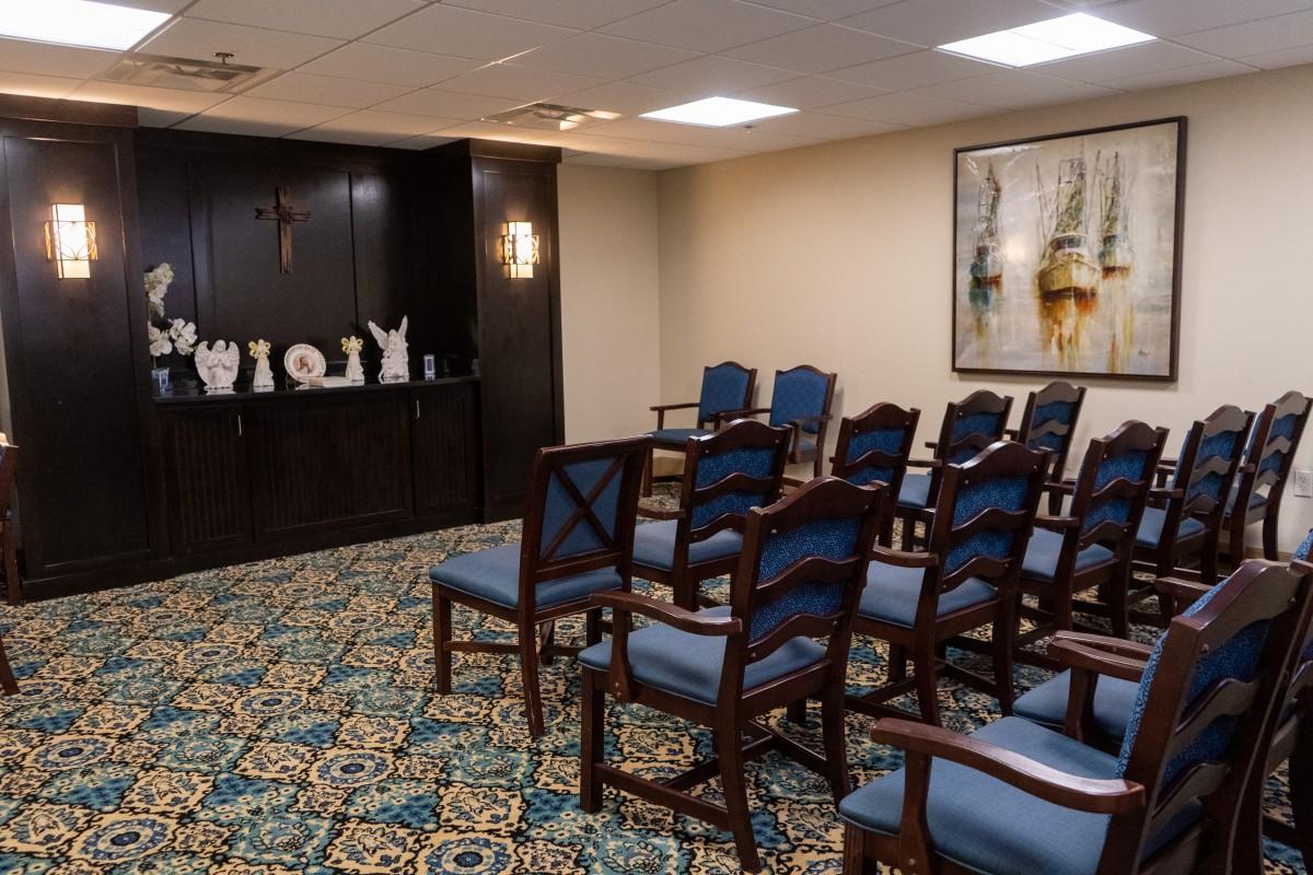A small, decorated room with rows of chairs and artwork on the walls.