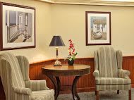 A cozy living room setup with two chairs, a round table, and wall art.