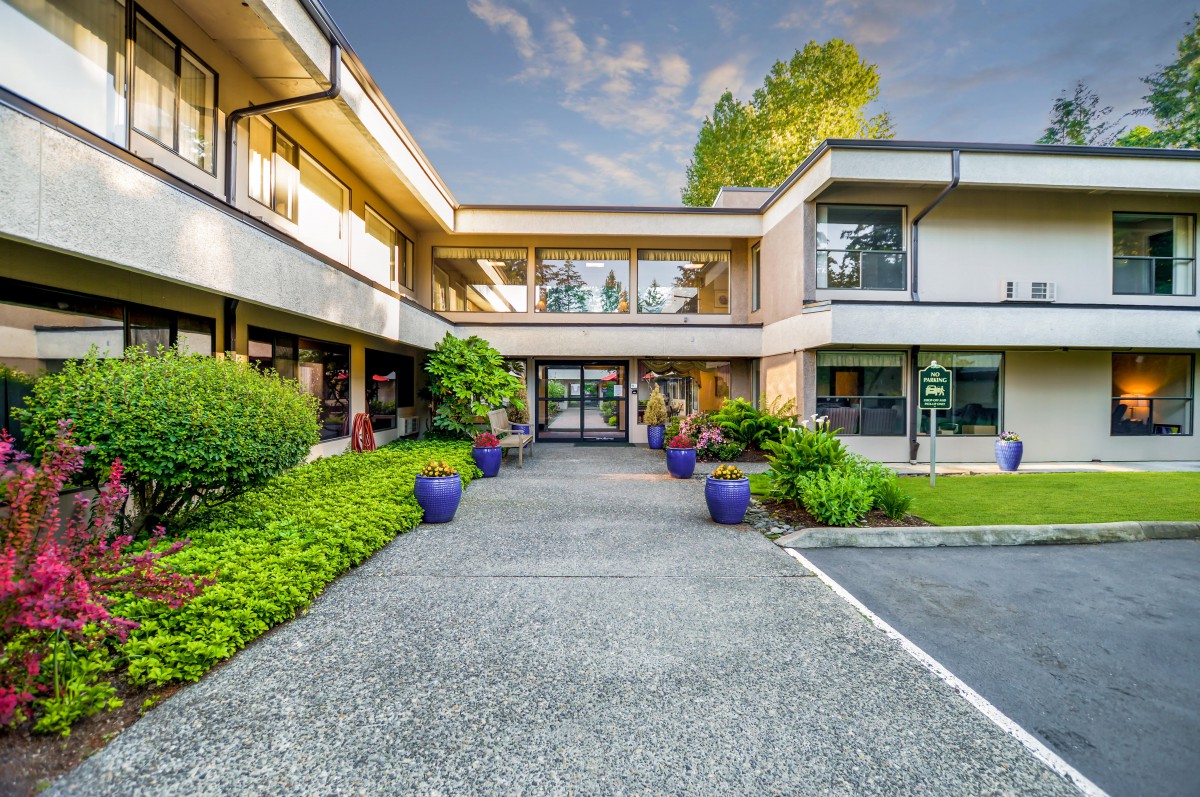 A modern building with large glass windows and well-maintained landscaping.