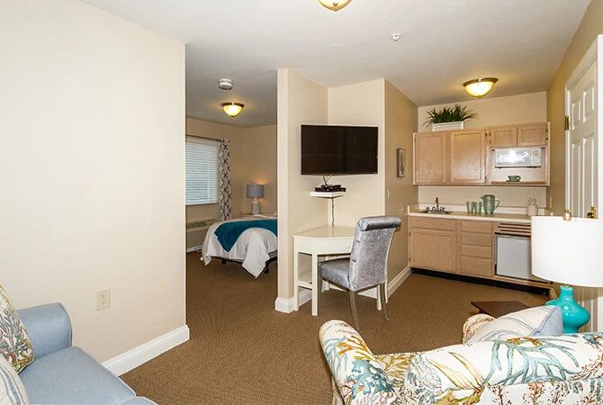 A cozy studio apartment featuring a bedroom, kitchenette, and living area.