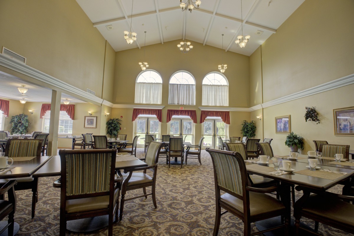A spacious dining room with elegant furnishings and large windows allowing natural light to fill the space.
