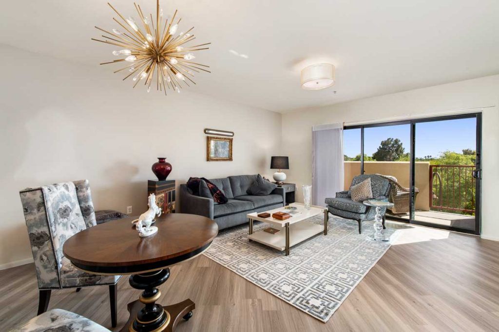 A stylishly decorated living room featuring modern furniture and a large window with a view.