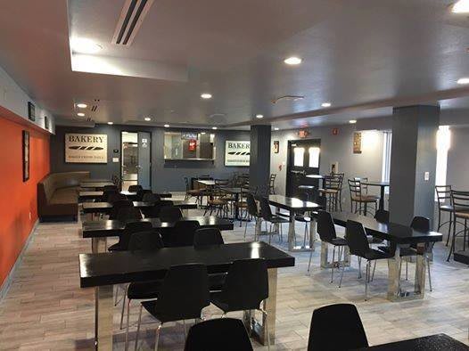A modern cafeteria with neatly arranged tables and chairs.