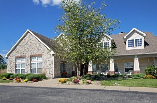 A suburban house with a tree and well-maintained landscaping.
