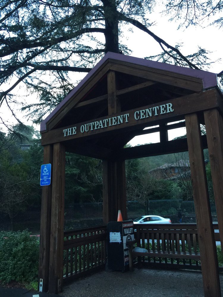 Entrance to The Outpatient Center with wooden signage and surrounding nature.