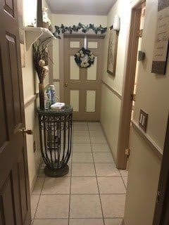 A decorated hallway with a wreath on the door and a basket in front.