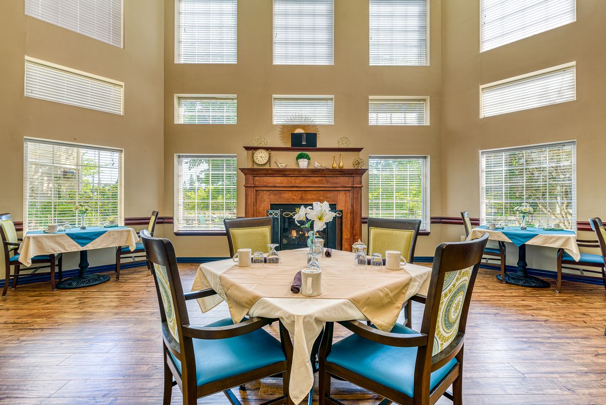 Spacious dining area with large windows and a central fireplace.
