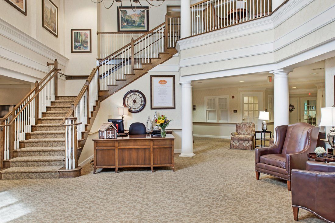 A welcoming lobby area featuring a reception desk, elegant staircase, and comfortable seating.