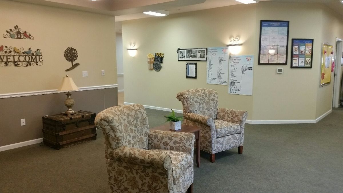 A cozy waiting room with upholstered chairs and a small table with a plant.