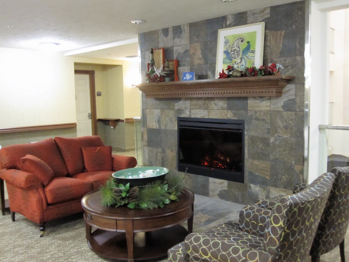 A cozy living room featuring a stone fireplace, comfortable seating, and decorative elements.