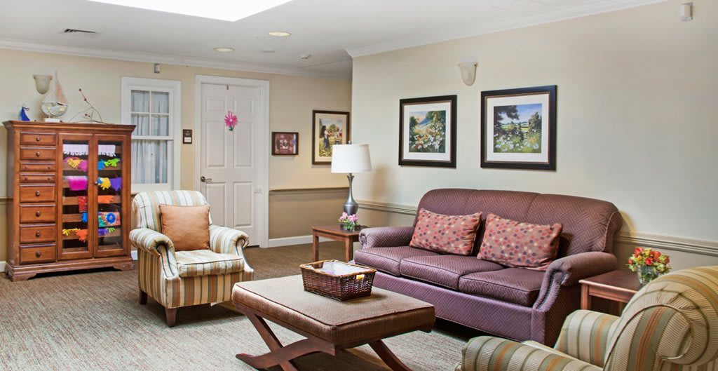 A cozy living room with a sofa, armchair, coffee table, and decorative items.