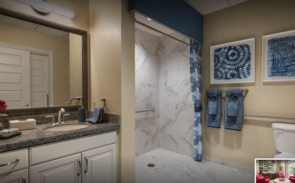 A modern bathroom with a marble shower and stylish decor.