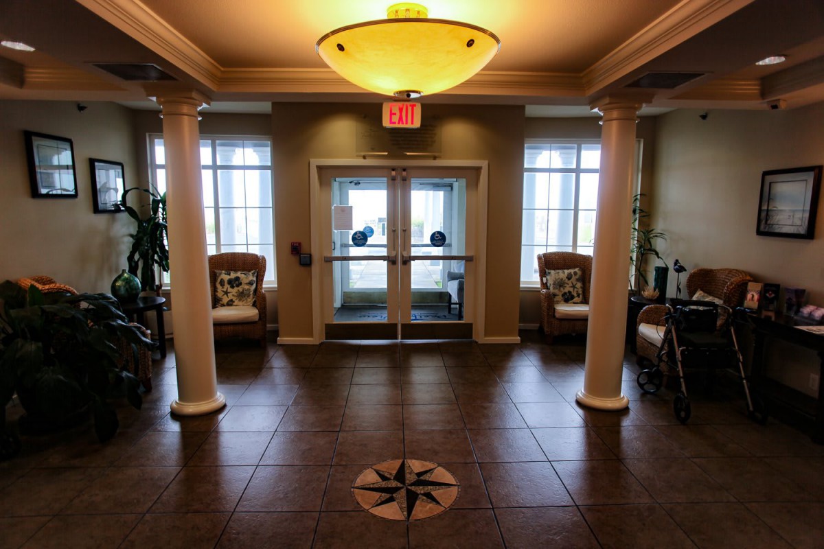 A cozy lobby entrance with columns, seating areas, and natural light.