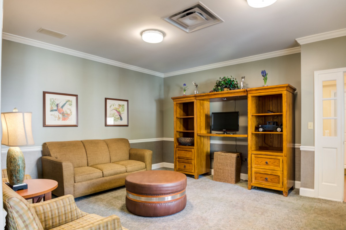 A cozy living room featuring a sofa, entertainment center with a television, and tasteful decor.