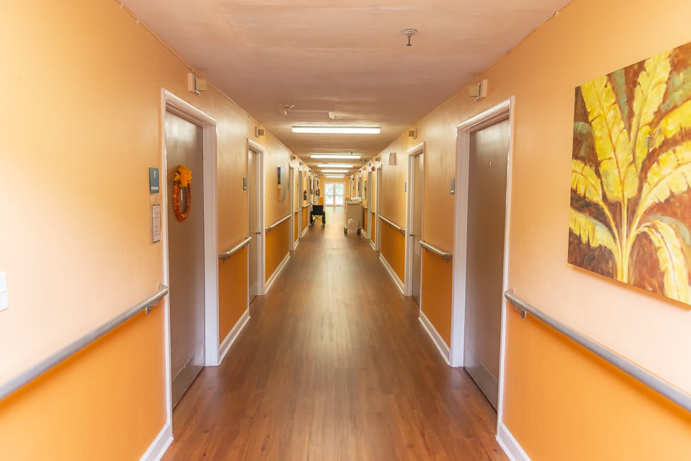 A brightly lit hallway with multiple doors on each side.