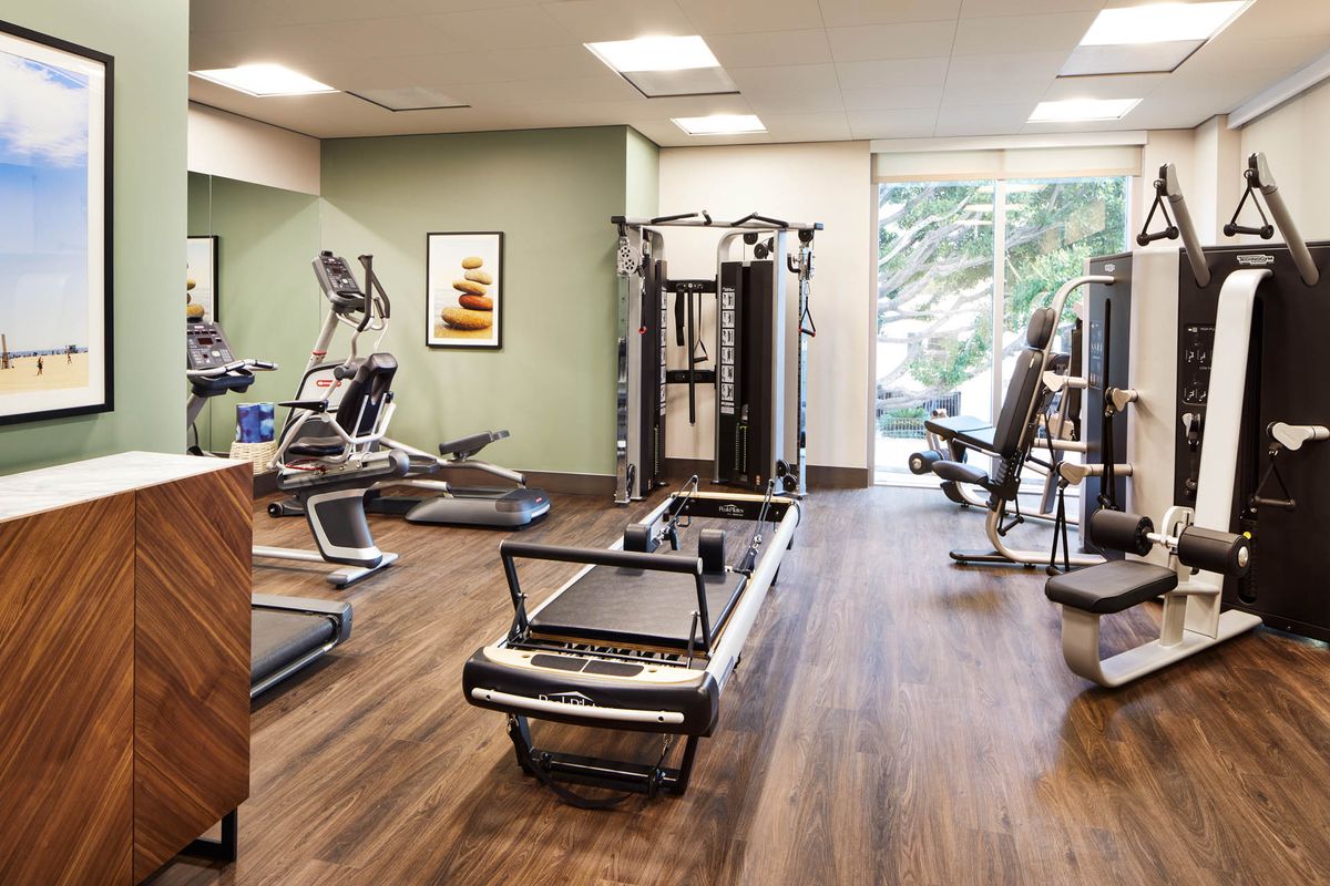 A modern gym featuring various exercise equipment including treadmills and weight machines.