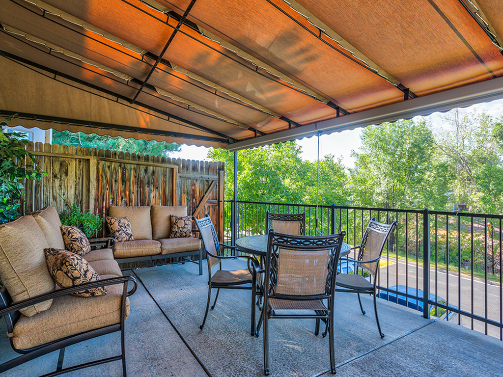 An inviting outdoor patio area with a canopy, featuring comfortable seating and a table for relaxation.