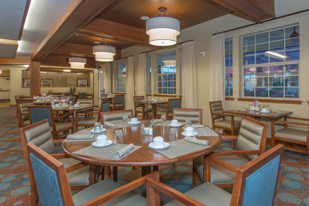 A cozy and elegant dining room with wooden tables and chairs set for a meal.