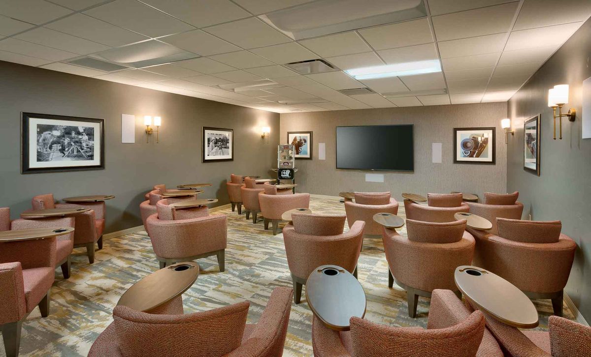 A modern conference room equipped with comfortable chairs and a large screen for presentations.