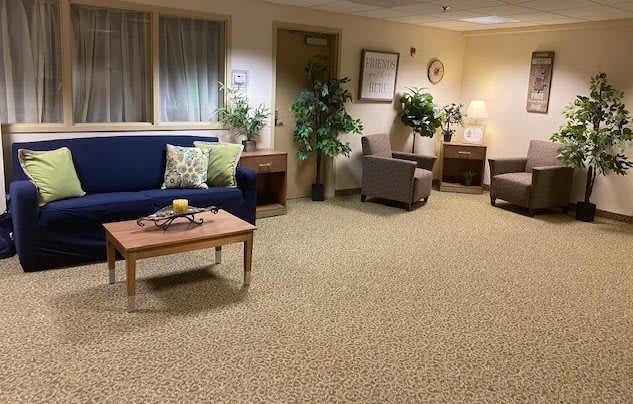 A cozy waiting room with comfortable seating and indoor plants.