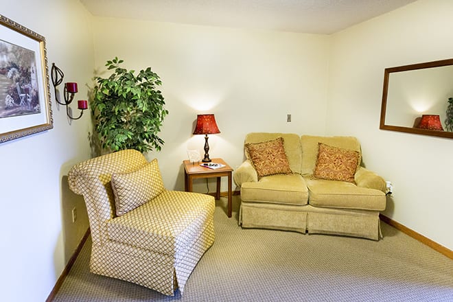 A cozy living room with a sofa, armchair, and decorative elements.