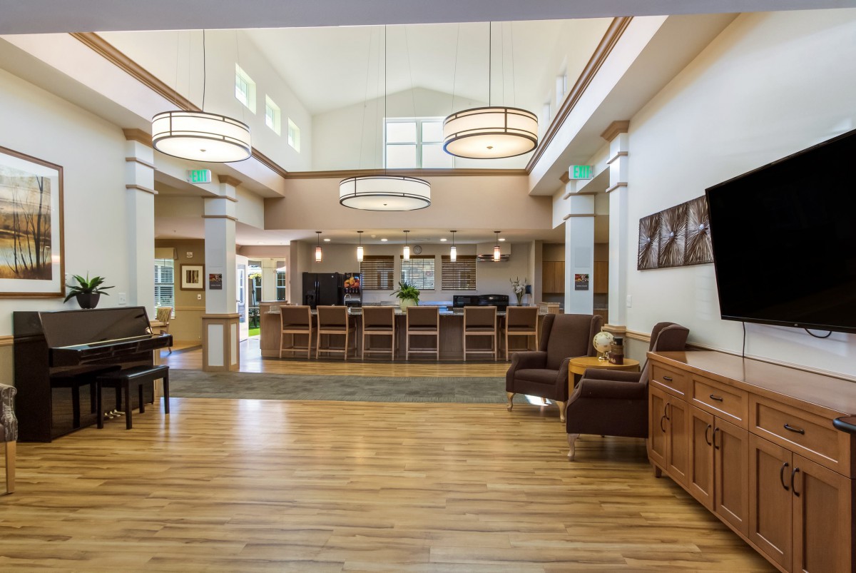 A modern lobby with comfortable seating, elegant lighting fixtures, and wood flooring.