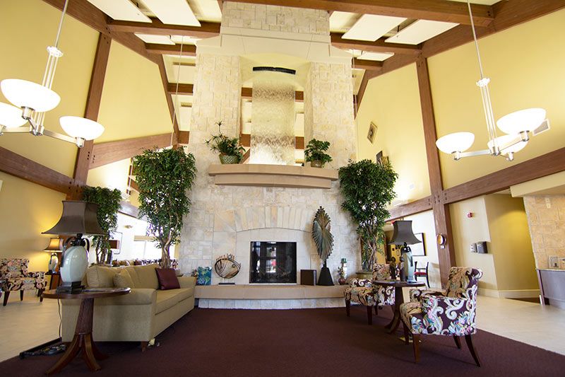 A cozy and spacious lobby featuring a large fireplace and comfortable seating.