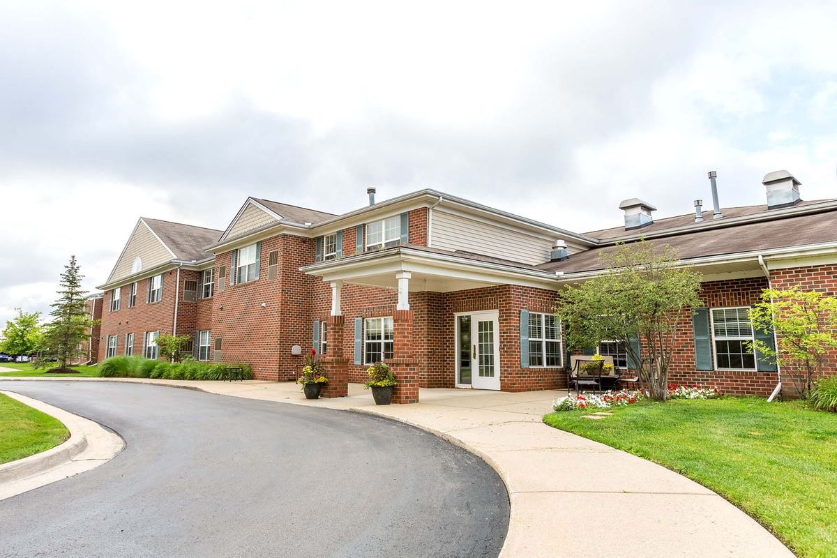 A modern residential building with a brick facade and landscaped entrance.