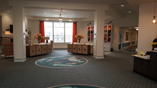 A welcoming lobby area featuring reception desks, floral decorations, and natural light.