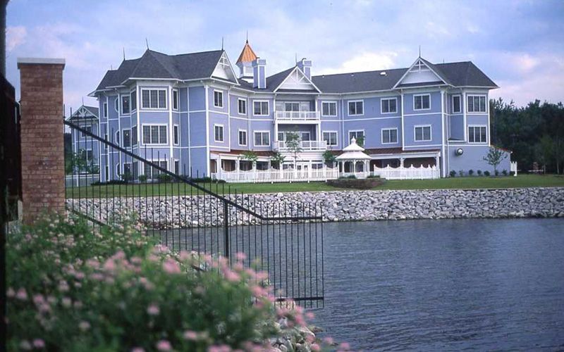 A large, elegant building with a waterfront view and manicured landscape.