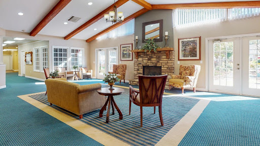 A spacious and inviting lobby area featuring comfortable seating, a fireplace, and natural lighting.