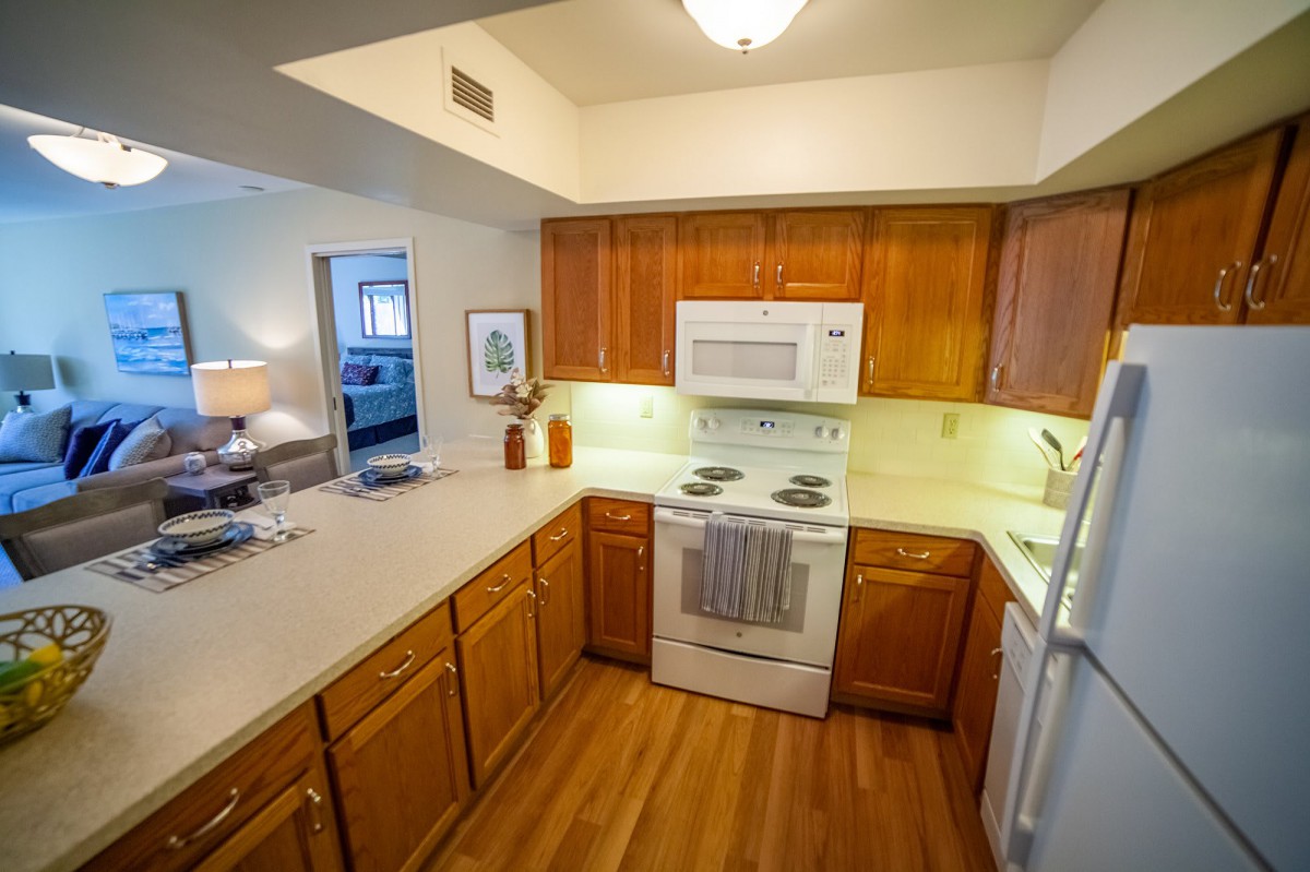 A modern kitchen with wood cabinets and a white countertop.