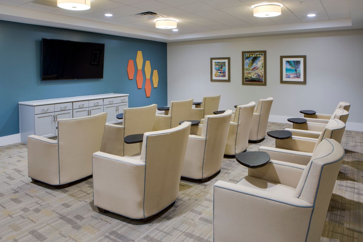 A modern conference room with comfortable seating and a large TV.