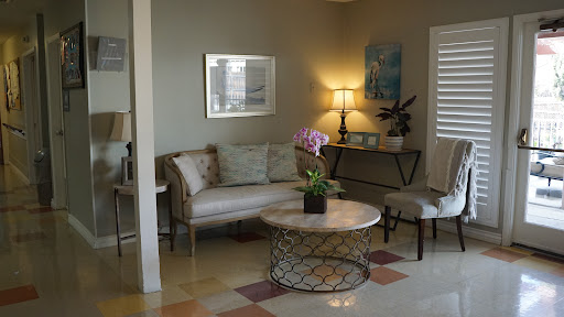 A cozy living room featuring a stylish sofa, a round coffee table with a plant, and soft lighting.