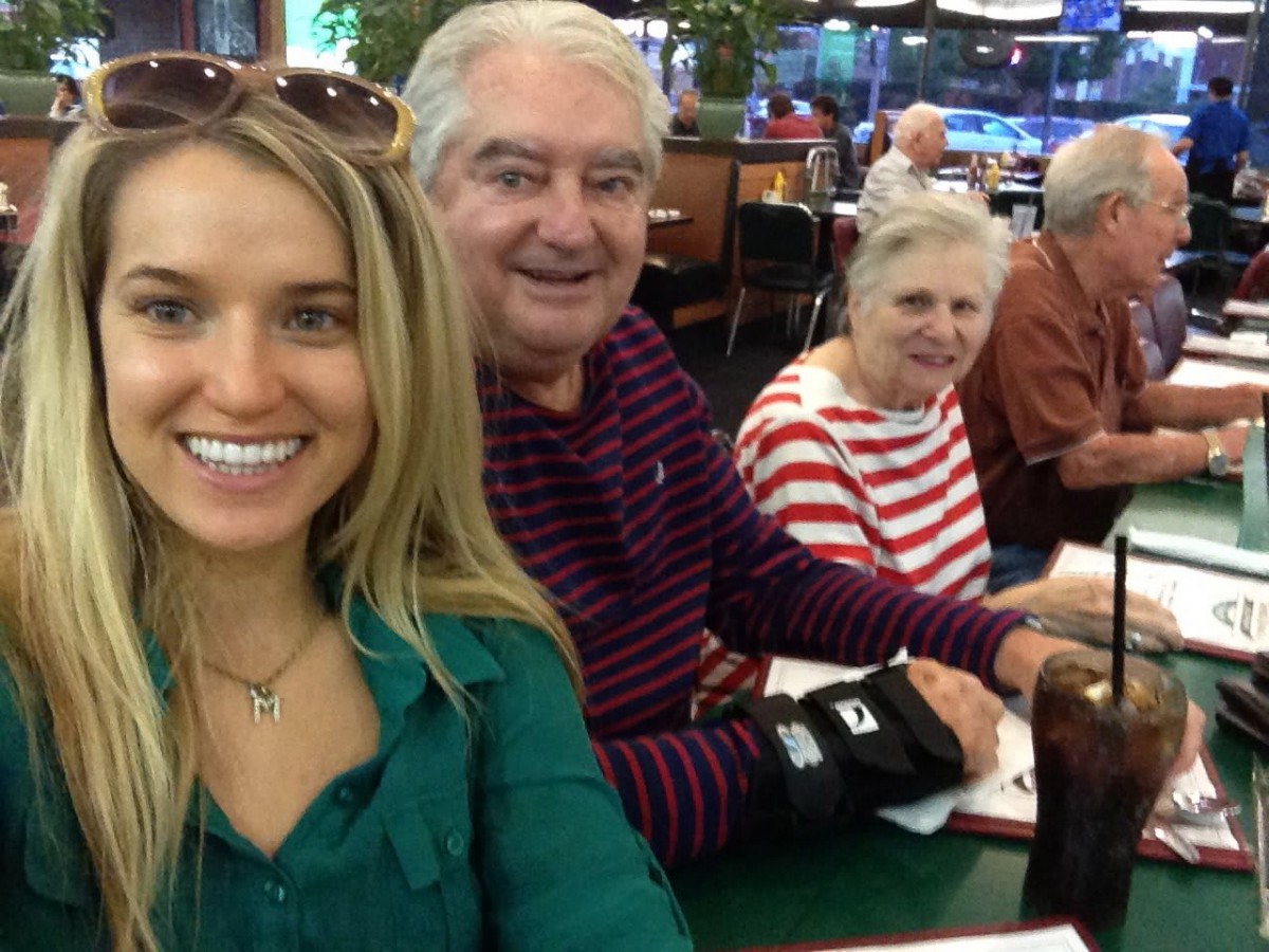 A group taking a selfie while enjoying a meal together at a restaurant.