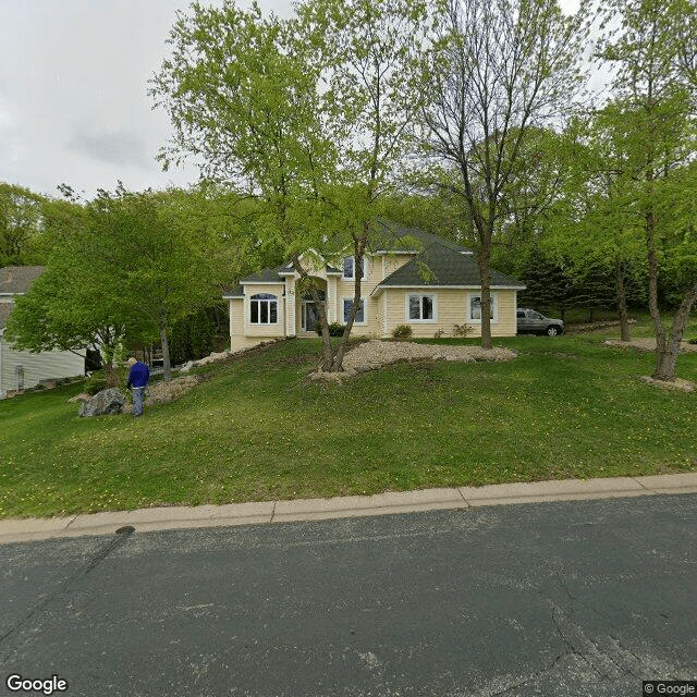 A suburban house with a well-maintained lawn surrounded by trees.