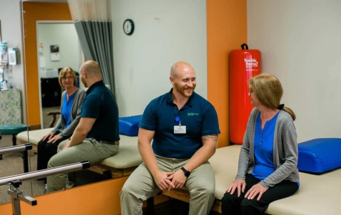Two individuals engage in a friendly conversation in a clinic setting.