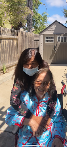 A joyful moment shared between a caregiver and an elderly woman, enjoying the sunshine outdoors.