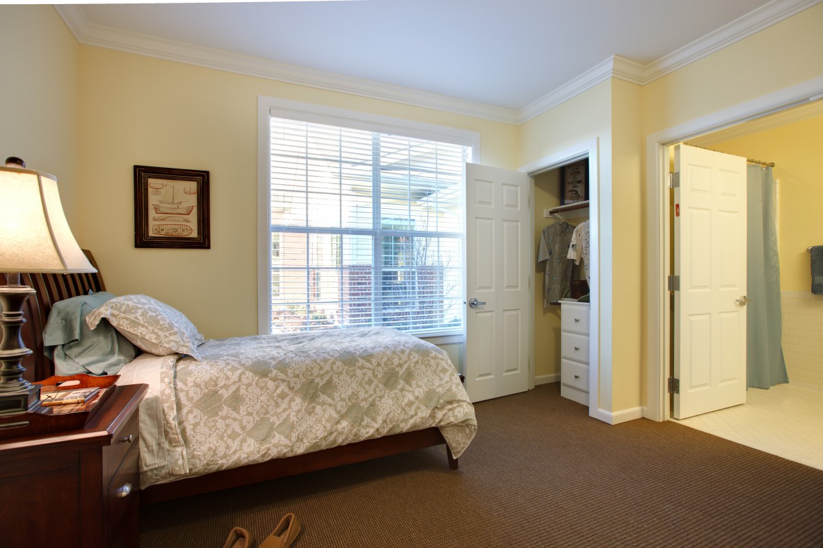 A cozy bedroom with a large window and an open closet.