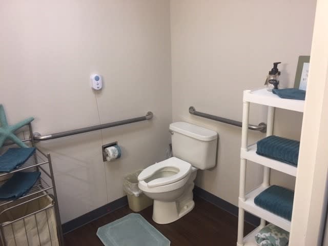 A clean and accessible bathroom with safety handrails and neatly organized towels.