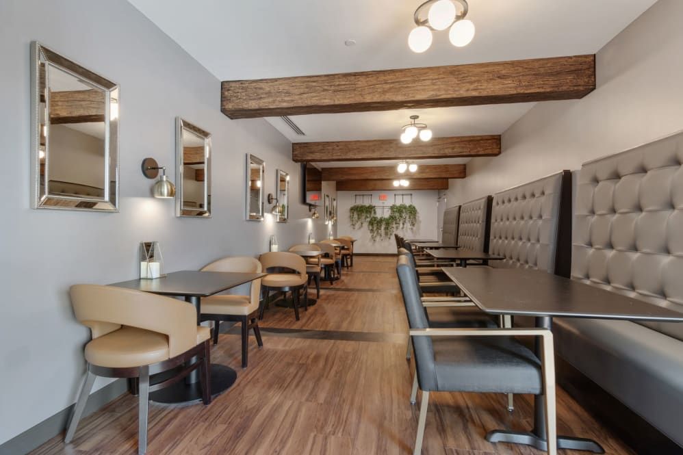 A modern restaurant interior featuring wooden beams, elegant lighting, and comfortable seating.