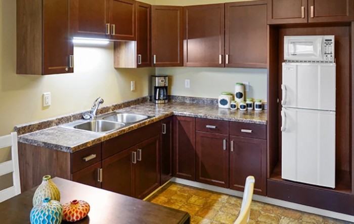A modern kitchen with dark wood cabinets and stainless steel appliances.
