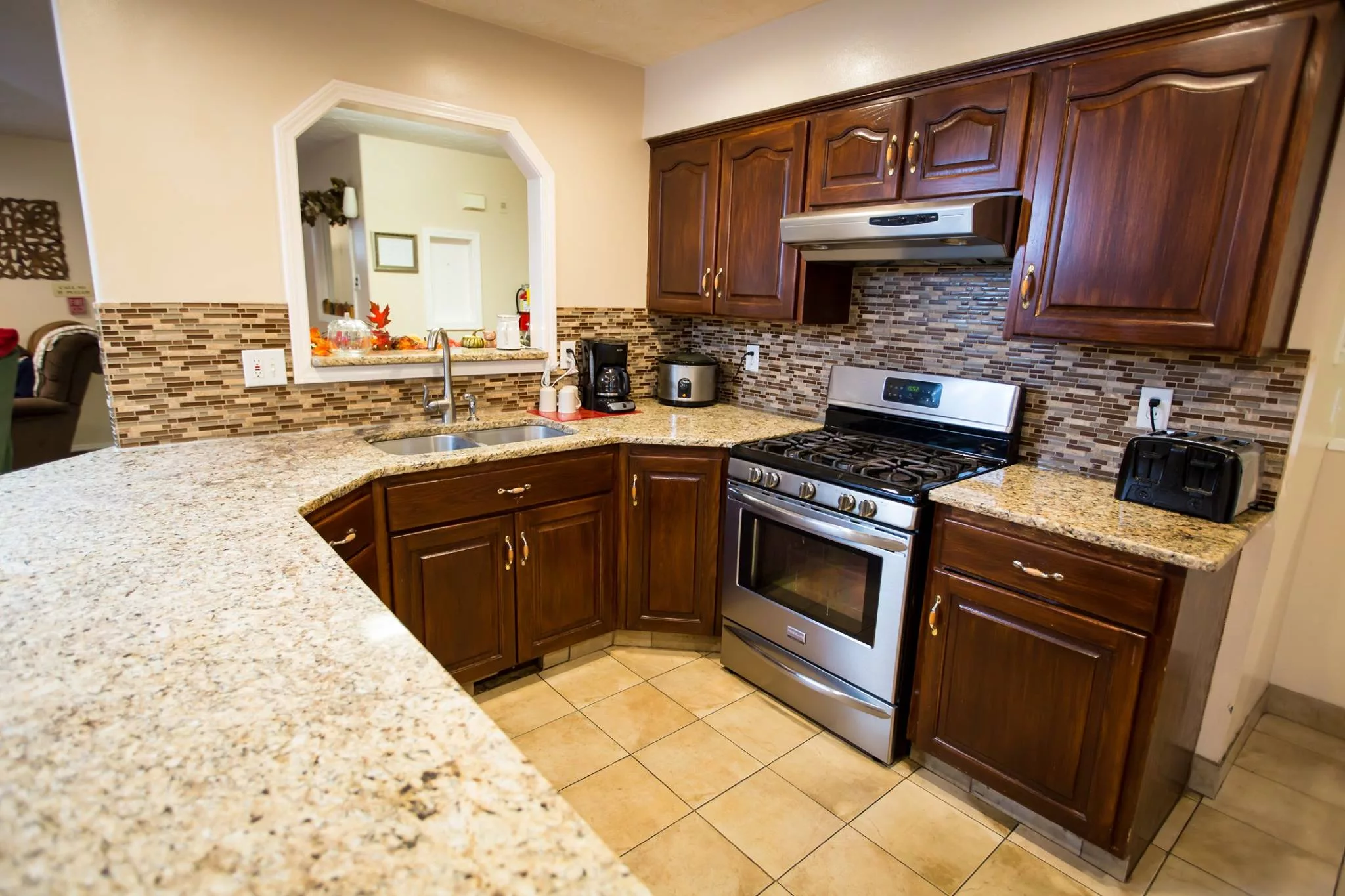 A modern kitchen with dark wood cabinets, stainless steel appliances, and a granite countertop.