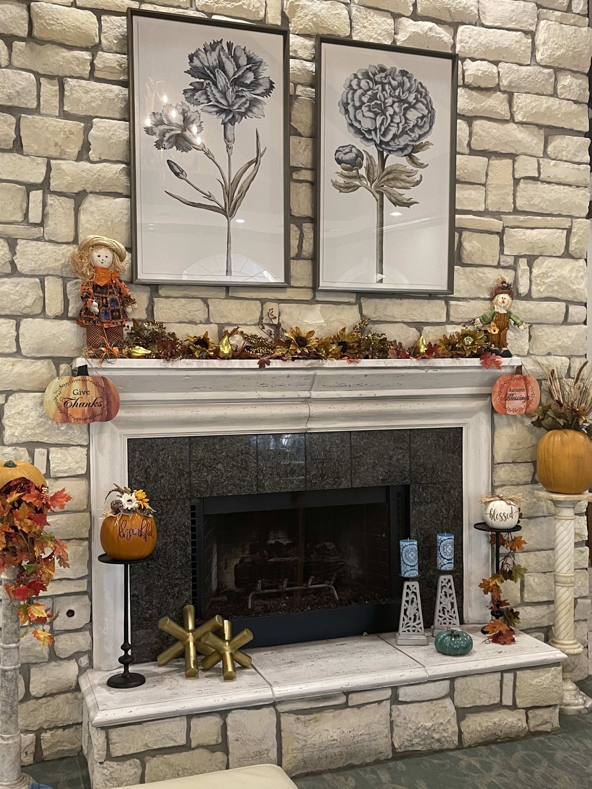 A cozy stone fireplace adorned with fall decorations, including pumpkins and candles, creating a warm autumn atmosphere.