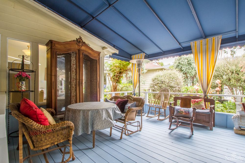 A cozy patio with wicker furniture under a blue canopy.
