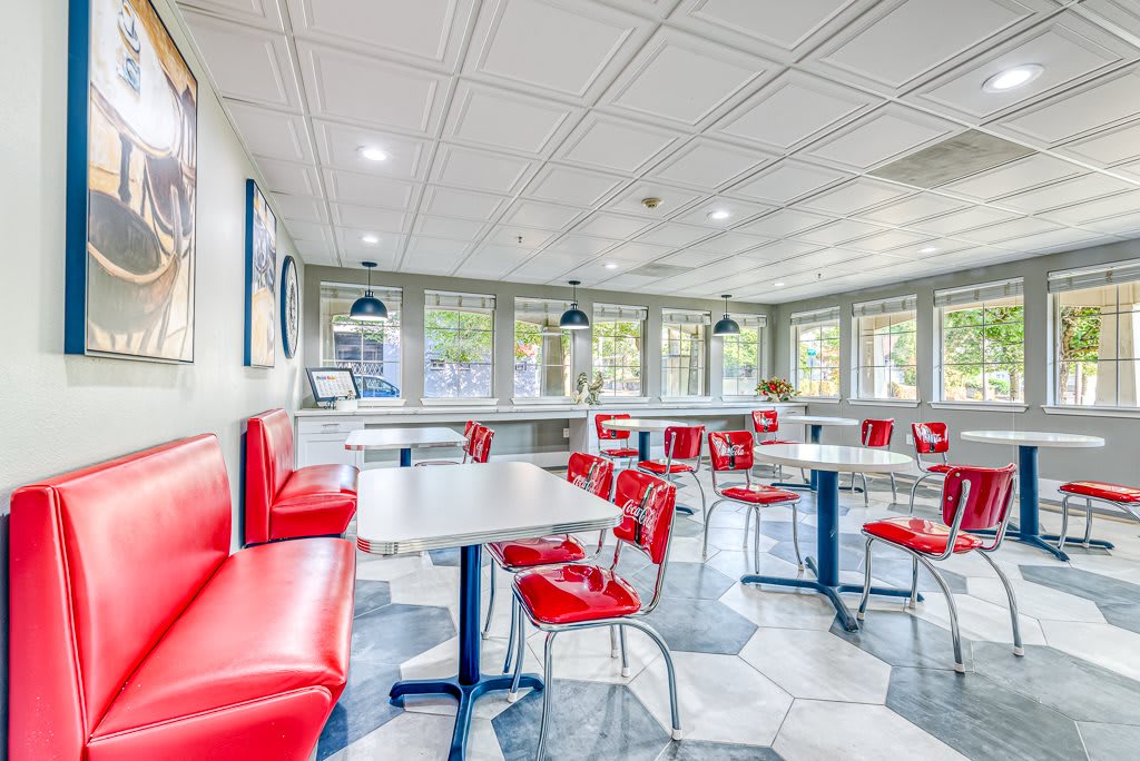 A retro-style diner with red chairs and booth seating, featuring a classic interior design.