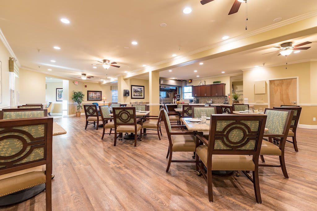 A spacious dining area with elegant furniture and warm lighting.
