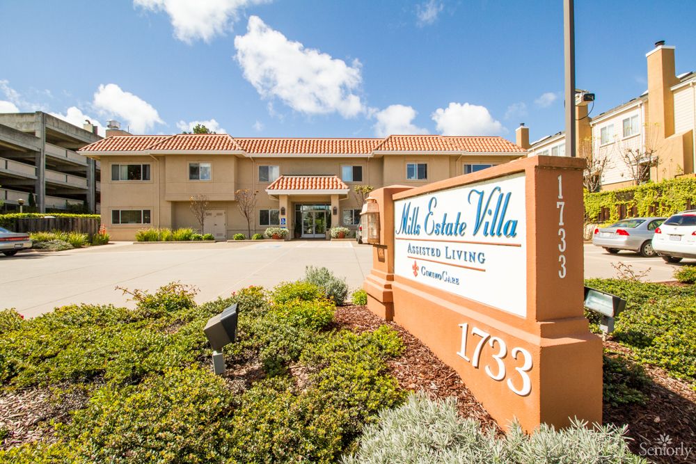 Exterior view of a hotel with clear signage and landscaped surroundings on a sunny day.