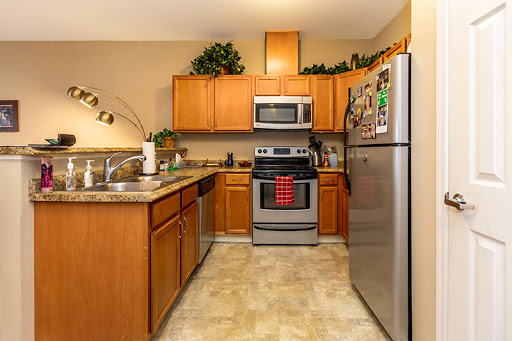 A modern kitchen featuring wooden cabinets, stainless steel appliances, and a well-organized layout.