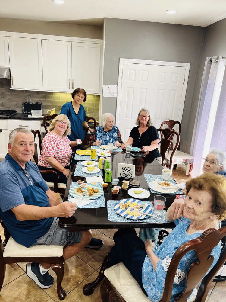 A group of people enjoying a meal together in a kitchen setting.
